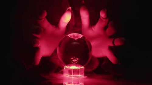 Diseuse de bonne aventure déplaçant les mains sur une boule de cristal, rituel magique, prophétie et prédiction