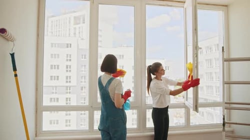 Ein Mitarbeiter eines professionellen Reinigungsdienstes in Overalls wäscht das Glas von