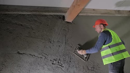Construction Worker Plastering a Wall in an Under-Construction Building