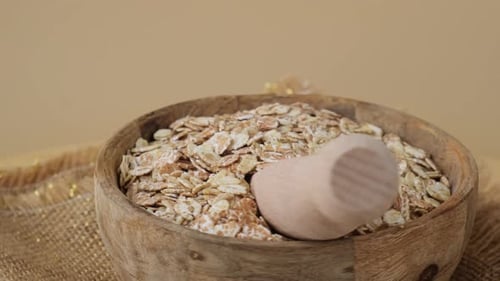 Rolled oats in a wooden bowl with scoop