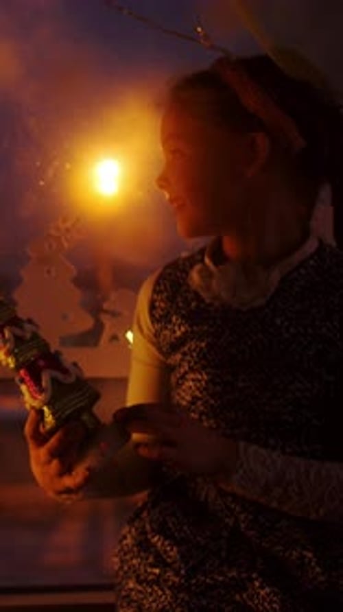 Child Admiring Decorative Figure Near Window During Cozy Winter Evening