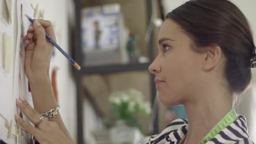 Close up of a Young female fashion designer working at home studio.