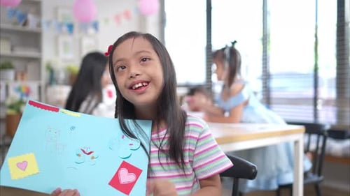 Smiling Child Presents Drawing at Birthday Party