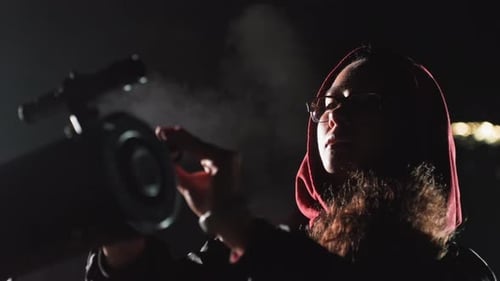 Girl Looks Through Telescope for Space Exploration at Night