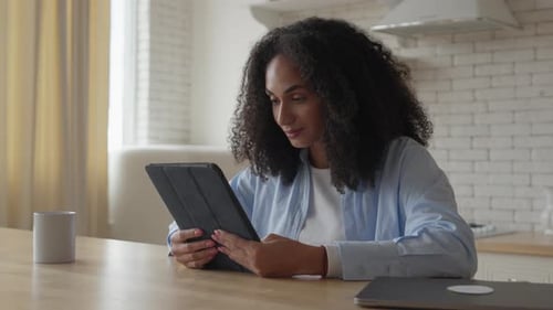 Woman Using Tablet Device at Home Indoors