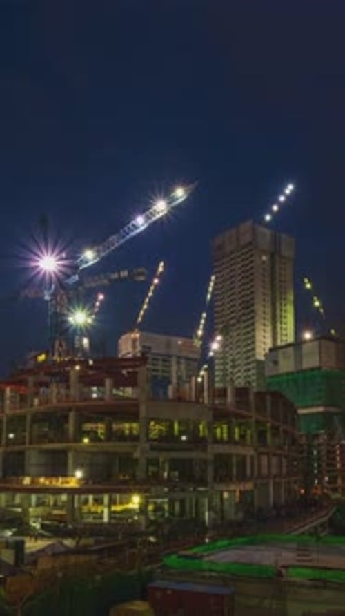 Night Timelapse of Construction Site Many Cranes Move Highrise Buildings in Middle of Modern City