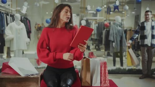 Woman Using Tablet While Shopping at Clothing Store