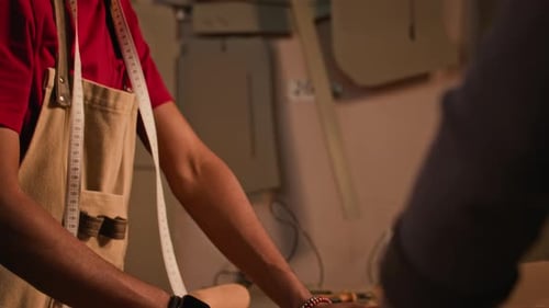 Young Black Artisan Measuring Leather Details with Colleague in Workshop