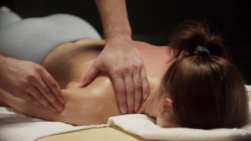 Masseur gibt Frau eine entspannende Rückenmassage