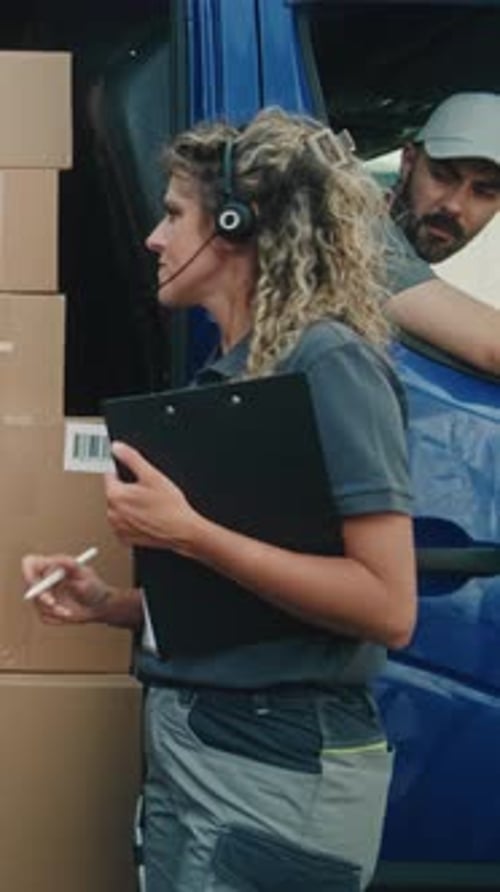 Employee Unloading Delivery Truck with Cardboard Boxes with Female Inventory Manager