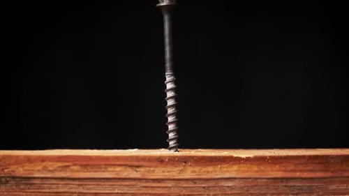 Power Drill Driving Screw Into Piece of Wood