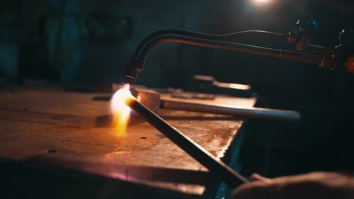 Metal Worker Using Blowtorch for Welding in Workshop