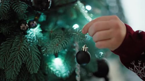 Child Decorates Christmas Tree With Ornaments