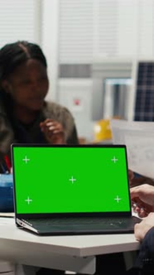 Vertical Video Factory Manager Works on Facility Upgrades Schematic Using Mockup Laptop