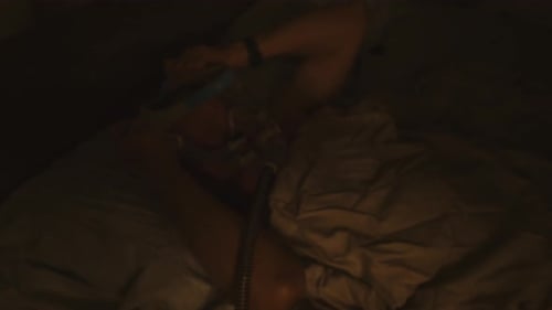 senior citizen puts on CPAP harness at night on his head for nighttime breathing treatment therapy