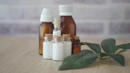Homeopathic Medicine Bottles with White Pills and Leaf