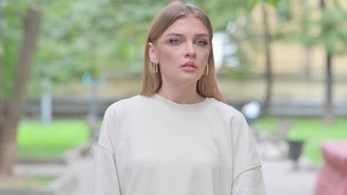 Young Adult Woman Looking At Her Watch Outdoors