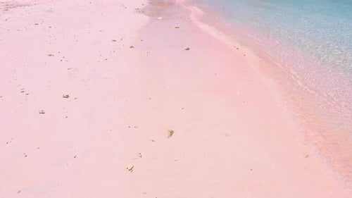 Popular tourism destination of Pink Beach with ocean waves lapping onto sand in East Nusa Tenggara,