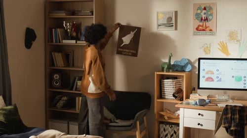 Black Boy Hanging School Timetable on Wall to Replace Superhero Poster