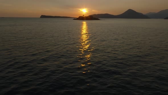 Cinematic drone view with camera rise from the reflection of the sunset ...