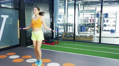 Girl in sport gym, bodybuilding equipment, skipping exercise training, skipping jump rope for cardio