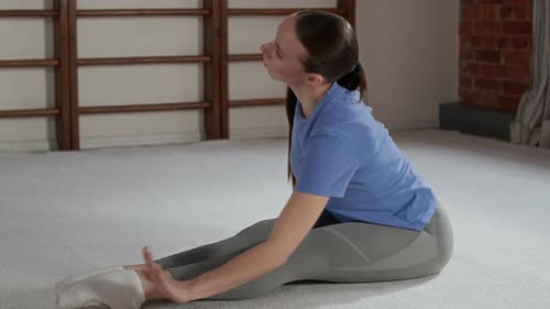 Young Flexible Woman in Sportswear Exercising on the Floor of Gym