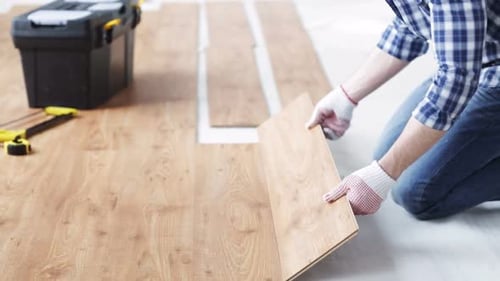 Repair, Building, Floor and People Concept - Close Up of Man Installing