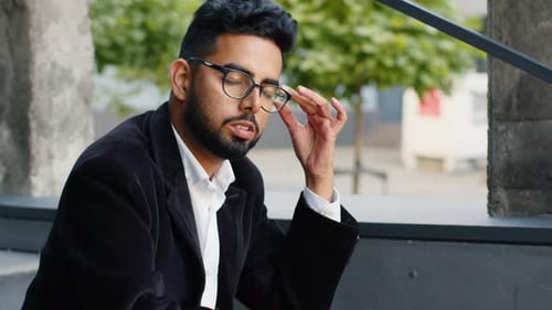Stressed Man Sitting on Concrete Steps Outdoors