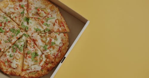 Appetizing Pizza in Box on Yellow Background
