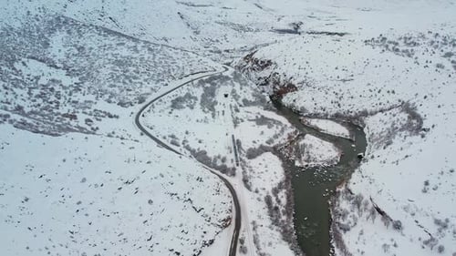 Train Passing Through Snowy Winter Landscape Near River