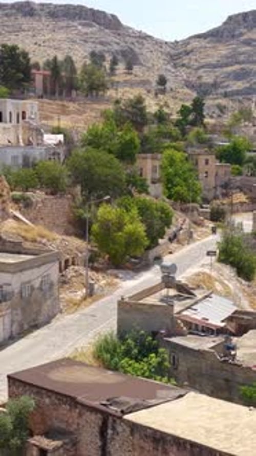 Vidéo verticale : village de Halfeti avec bâtiments en pierre et mosquée au bord de l'eau