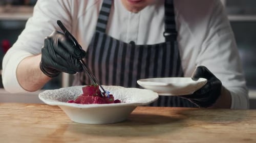 Male Chef Garnishing Tuna with Edible Flowers in Fine Dining Restaurant