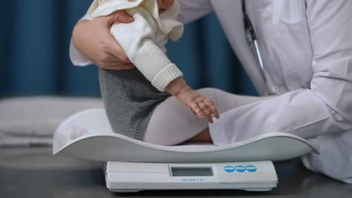 Side View Unrecognizable Pediatrician Putting Baby Girl on Scales in Slow Motion