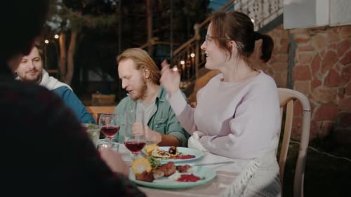 Friends Eating Dinner Outside at Night