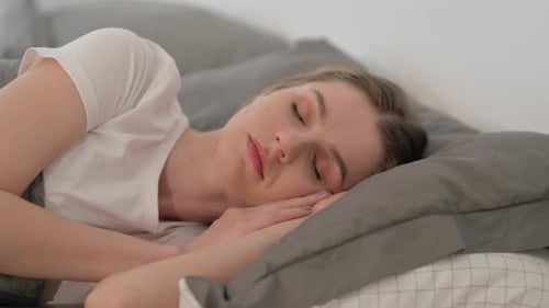 Woman Sleeping while Lying on Side in Bed