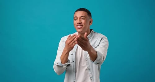 Smiling African American Man Throwing Air Kiss From Hand Standing Over Blue Studio Background