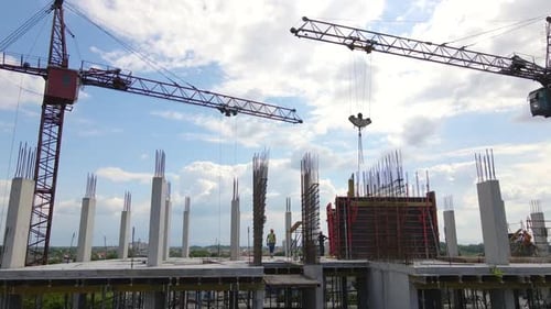 Guindastes de torre e trabalhadores em prédio residencial de alto concreto em construção