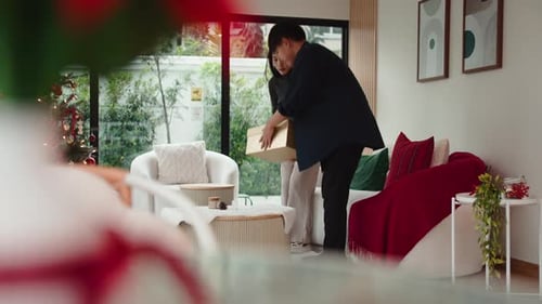Couple Unwrapping Christmas Gifts at Home Together