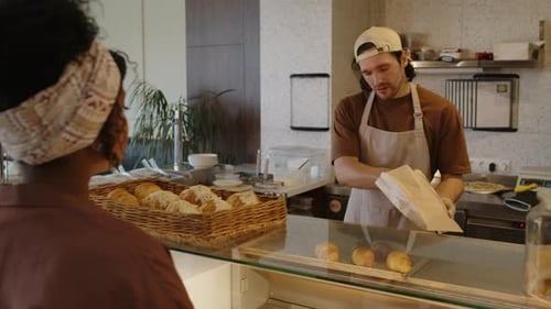 Salesman Serving Female Customer in Bakery
