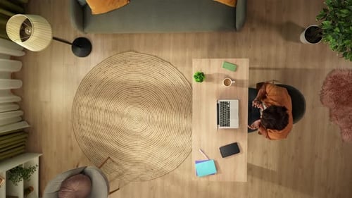 Top View Capturing a Man Having a Videocall Talking to Somebody on a Laptop in His Home Office Young