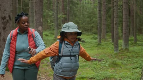 Woman sprays child with insect repellent in forest
