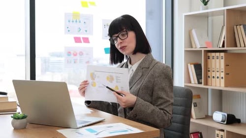 Caucasian Woman Pointing at Document with Infographics of Online Presentation