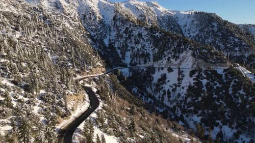 Aerial of a road through the mountains after a snow