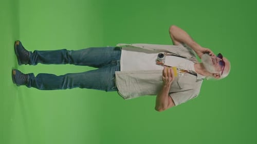 Vertical View Green ScreenA Happy Old Man Tourist is Talking on the Phone