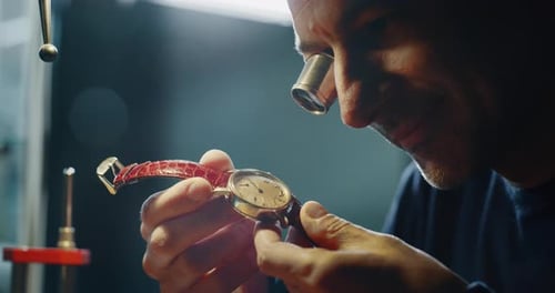 Slow motion close up of a professional watchmaker repairer working on an old vintage watch in a wo