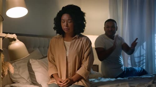 Upset Woman and Man Arguing on Bed