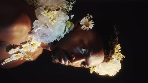 Studio Portrait of Young Black Man Adorned with Flowers