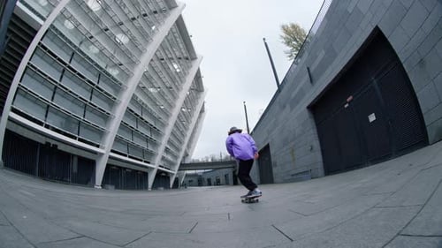Sporty hipster riding skateboard outdoor in slow motion making extreme trick at city street