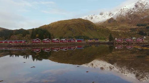 Scenic Red Cabins Reflected in Calm Water
