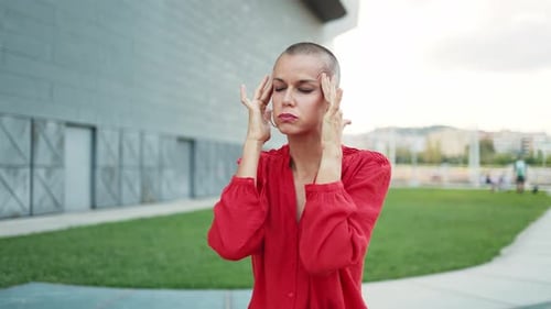 Femme adulte stressée aux cheveux rasés et souffrant de migraines à la tête. Surcharge de travail